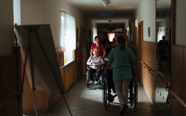 Opiekunowie pchający wózki inwalidzkie z seniorami