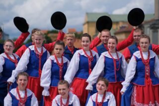 Grupa w tradycyjnych polskich strojach ludowych na zewnątrz