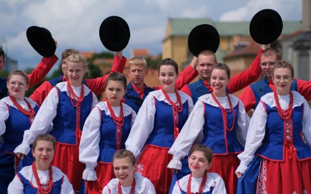 Grupa w tradycyjnych polskich strojach ludowych na zewnątrz