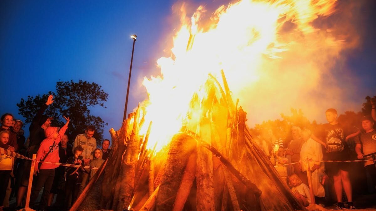 Wieczorne świętowanie przy ognisku z tłumem ludzi