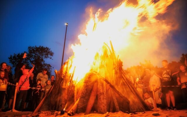 Wieczorne świętowanie przy ognisku z tłumem ludzi
