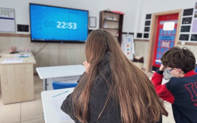 Uczniowie w klasie skupieni na cyfrowym stoperze