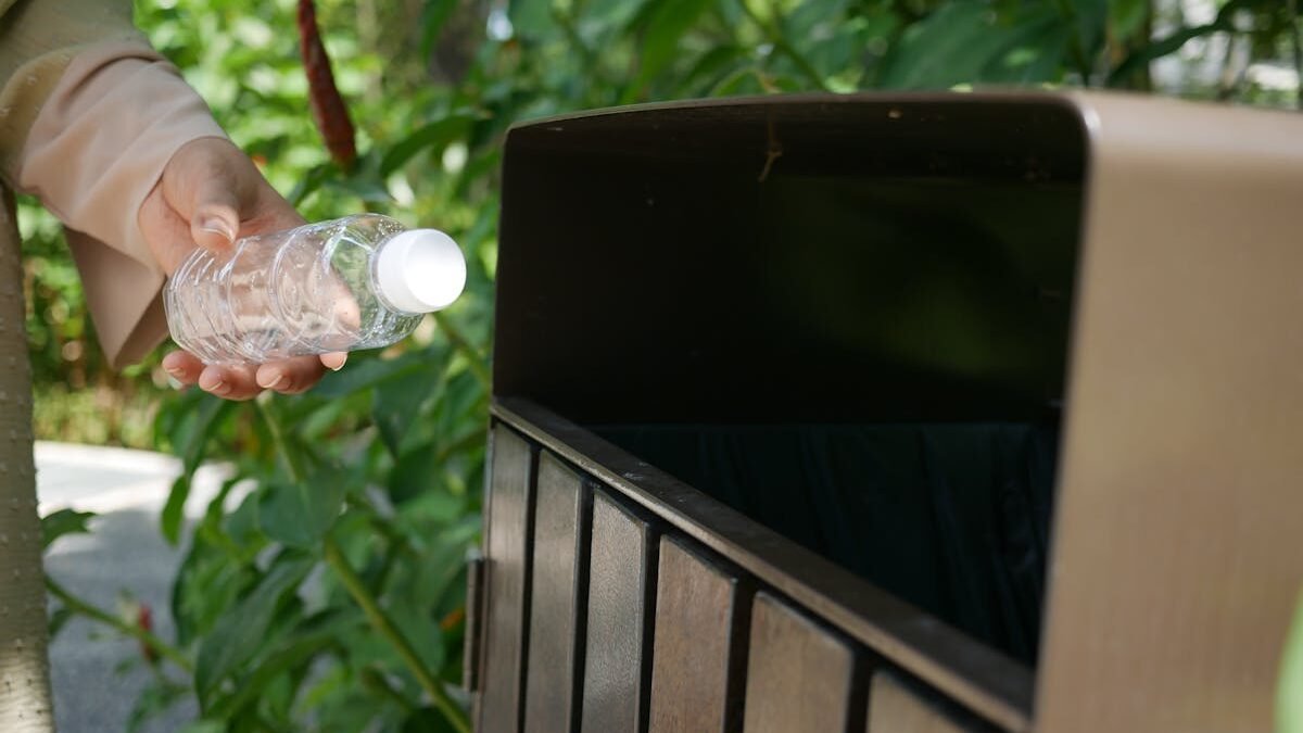 Osoba wyrzucająca plastikową butelkę