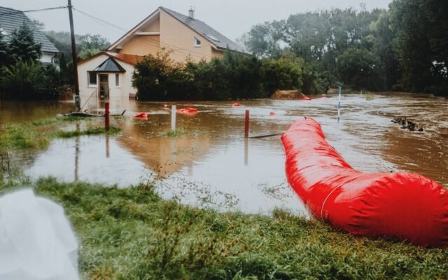 Zalany obszar mieszkalny z czerwoną barierą